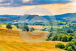 View of little city of Todi through fields and woods, Italy, in a summer sunny day photo