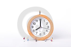 View of little figurines of students standing on and around a clock on white background