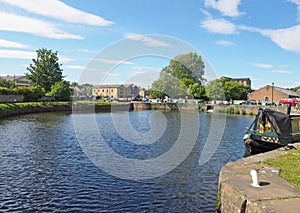 a view of the lock entrance to brighouse basin with moored houseboats on the calder and hebble navigation canal in calderdale west