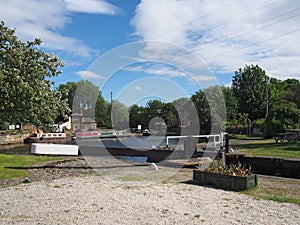 view of the lock gates at brighouse basin on the calder and hebble navigation canal with barges and canalside buildings