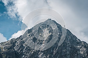 View of the Lomnicky stit peak, famous rocky summit in High Tatras, Slovakia. Cloudy windy day.