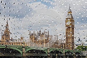 View on London city through water drops on glass after rain. Weather and forecast concept