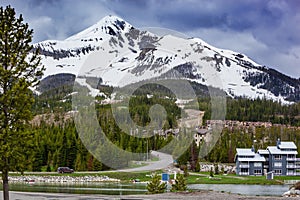 View of Lone Mountain with buildings and pine trees on the foot of the mountain, Big Sky, Montana, USA photo