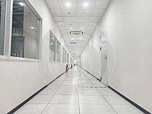 A view into a long corridor indoor inhouse glass window factory walkway led lighting white lighting