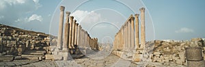 A view looking down the Cardo showing stone carved columns and paved street at the ancient city of Jarash or Gerasa, Jerash in