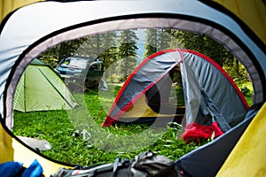 View looking out of door of sun-filled tent upon great outdoors scenery. Morning in the tent camp