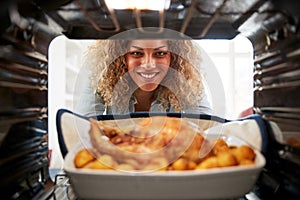 View Looking Out From Inside Oven As Woman Cooks Sunday Roast Chicken Dinner