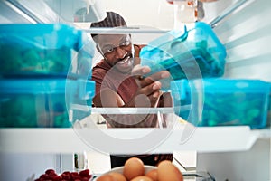 View Looking Out From Inside Of Refrigerator As Man Takes Out Healthy Packed Lunch In Container