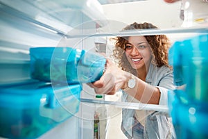 View Looking Out From Inside Of Refrigerator As Woman Takes Out Healthy Packed Lunch In Container