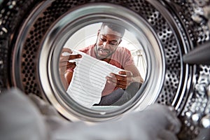 View Looking Out From Inside Washing Machine As Man Takes Out Baby Clothes