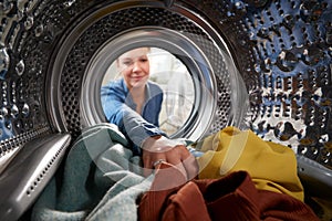 View Looking Out From Inside Washing Machine As Young Woman Does Laundry photo