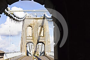 View looking out onto the Menai Suspension Bridge & A5 traffic route through an open-air stone archway, Gwynedd, North Wales