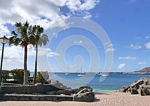 View looking out over the bay at Playa Blanca Lanzarote with yachts moored.