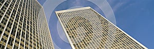 This is the view looking up at the Century City Towers. It is surrounded by blue sky during the day.