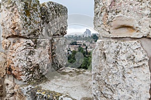 View through the loophole in the city`s fortress wall at the city near the Jaffa Gate in old city of Jerusalem, Israel