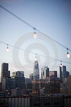 View Of Los Angeles Skyline At Sunset With String Of Lights In Foreground