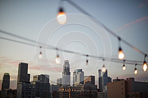 View Of Los Angeles Skyline At Sunset With String Of Lights In Foreground