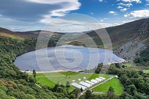 View on Lough Tay with a movie set related to Viking era with longships and village