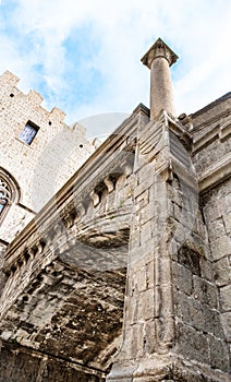 View of the lower part of the stone bridge with a column, covered with mold and dark spots. Vertical photo