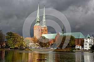 View of Lubeck Cathedral from Muhlenteich Mill pond in autumn,