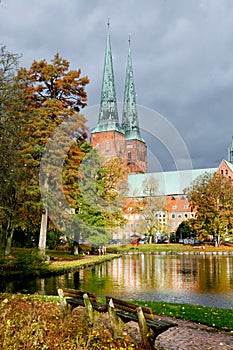 View of Lubeck Cathedral from Muhlenteich Mill pond in autumn,