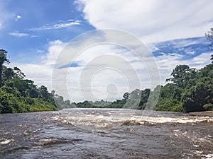 View of the Lucala river, with tropical vegetation and blue sky cloudy as background