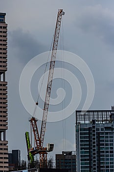 View of luffing jib tower crane at condominium construction site