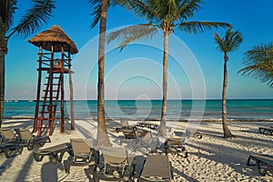 View at luxury resort hotel beach of tropical coast. Place of lifeguard. Leaves of coconut palms fluttering in wind