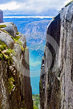 View of Lysefjorden through a crevice between two cliffs 984 meters high, where the famous Kjeragbolten stuck nearby. Norway