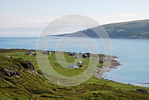 View of Mageroya with small fishing village near blue fjord.