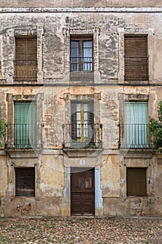 View of the main facade of an old building in ruins, with numeral 1 on the door, in the historic center of Cuidad Rodrigo downtown photo