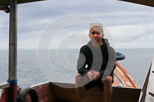 view of a man enjoying on the sailing traditional boat heading to Rangko Cave West Manggarai East Nusa Tenggara photo