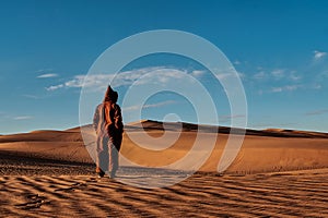 View of a man in local dress standing on a yellow sand dune