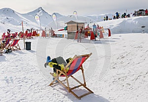 View of man resting on chair in mountains. Ski resort Livigno