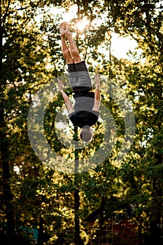 View of man skillfully jumps and performs trick upside down in the air