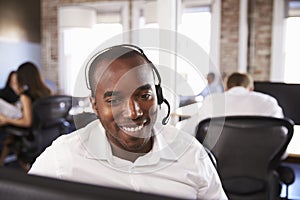 View Of Man Working In Busy Customer Service Department