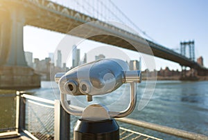 View of Manhattan bridge and New York City with a coin operated telescope binoculars viewer for tourists