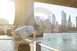 View of Manhattan bridge and New York City with a coin operated telescope binoculars viewer for tourists