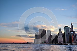 View of Manhattan Financial District and the Statue of Liberty from Brooklyn Bridge Park at Dusk - New York City, USA