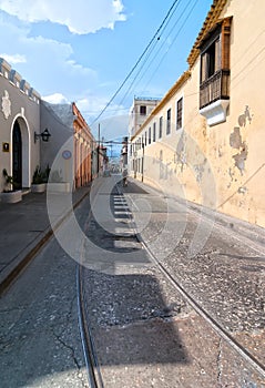 View of Mariano Corona street with locals and old tramway rails