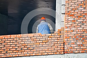 View of mason laying bricks at construction site