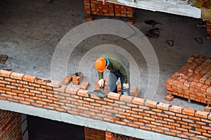 View of mason laying bricks at construction site