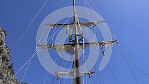 View of the mast of yacht sailing among mountain cliffs