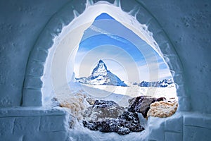 View of Matterhorn peak seen through ice igloo on snowy landscape