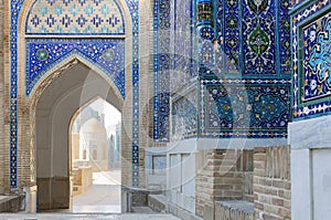 View of the mausoleums and domes of the historic Shahi Zinda cemetery through an arched gate, Samarkand, Uzbekistan