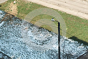 A view of the meadow, on which snow is still lying in the shade, and fresh grass is already sprouting in the sun. Early