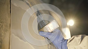 View of measuring a thickness of primer on a car surface using a thickness gauge