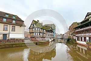 view of medieval buildings reflection on the channel at little france quarter in Strasbourg by winter