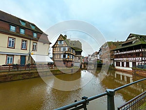 view of medieval buildings reflection on the channel at little france quarter in Strasbourg by winter