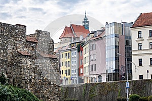 View of the medieval fortress wall against the background of buildings built in the 18th-20th century